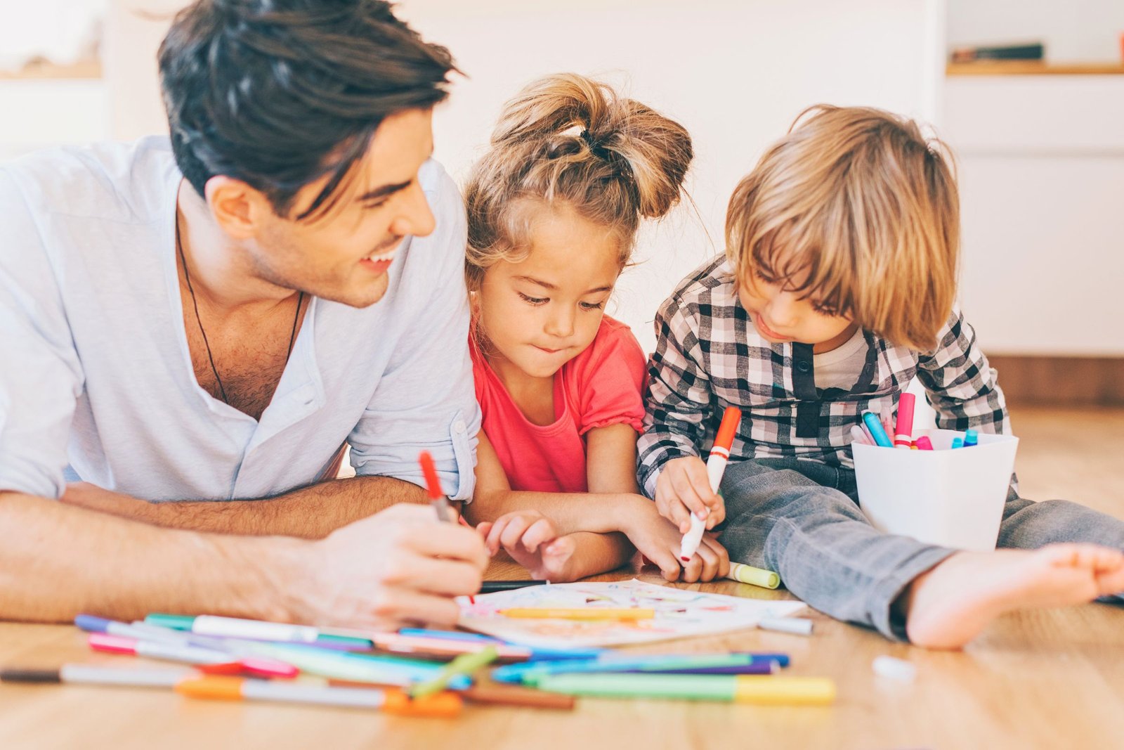 Kids develop their skills by coloring coloring pages with dad.