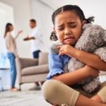 Parental Divorce. A little girl cries when she hears her parents arguing.