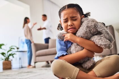 Parental Divorce. A little girl cries when she hears her parents arguing.